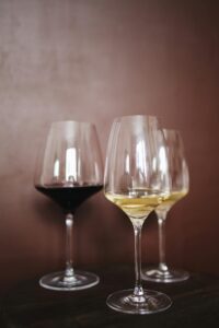 Elegant arrangement of red and white wine glasses on a dark surface, perfect for dining settings.